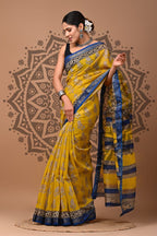 Woman wearing a yellow and blue saree with a decorative background