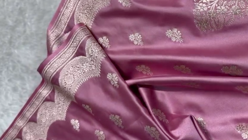 Pink fabric with intricate silver patterns on a textured surface