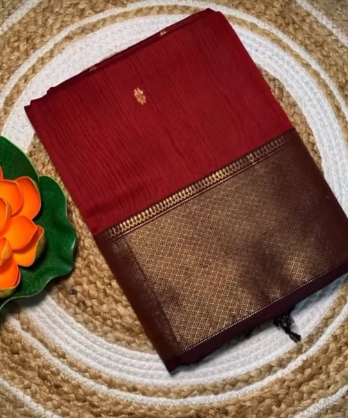 Red and brown saree with a floral decoration on a textured surface