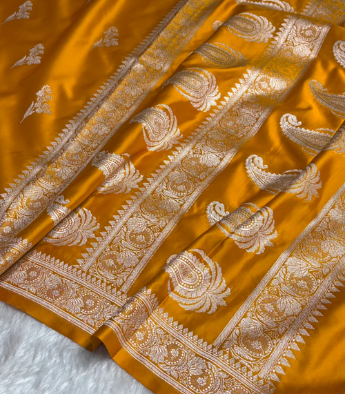 Mustard yellow fabric with intricate white patterns on a white background