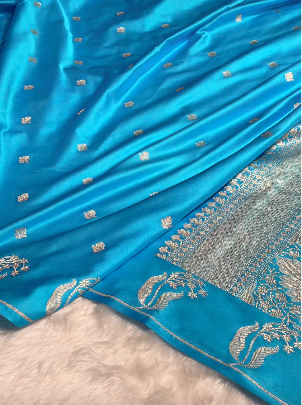 Blue saree with silver embroidery on a plain background