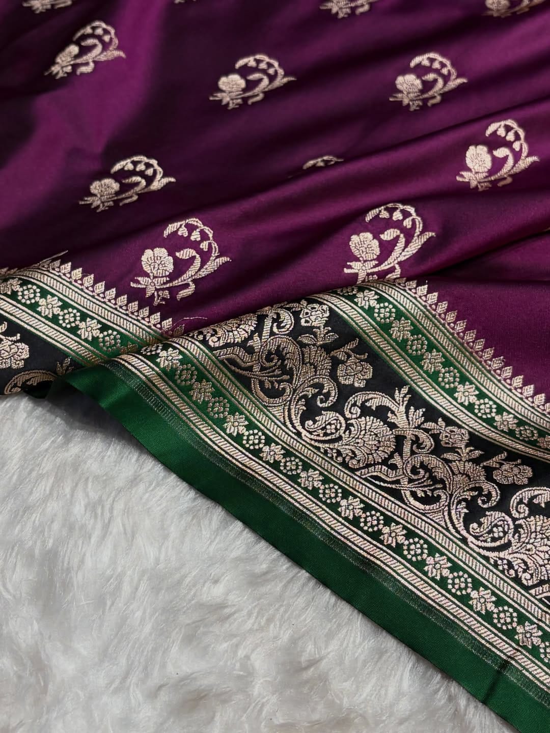 Purple fabric with white floral patterns and green border on a white background