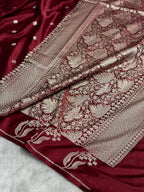Maroon saree with intricate gold embroidery on a white background