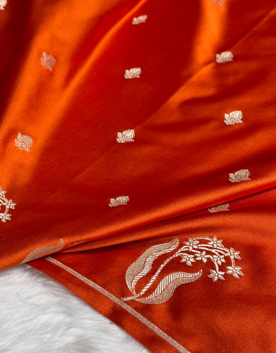Close-up of red fabric with gold embroidery on a white background