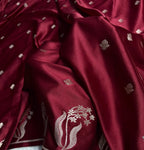 Close-up of a maroon fabric with floral embroidery on a white background