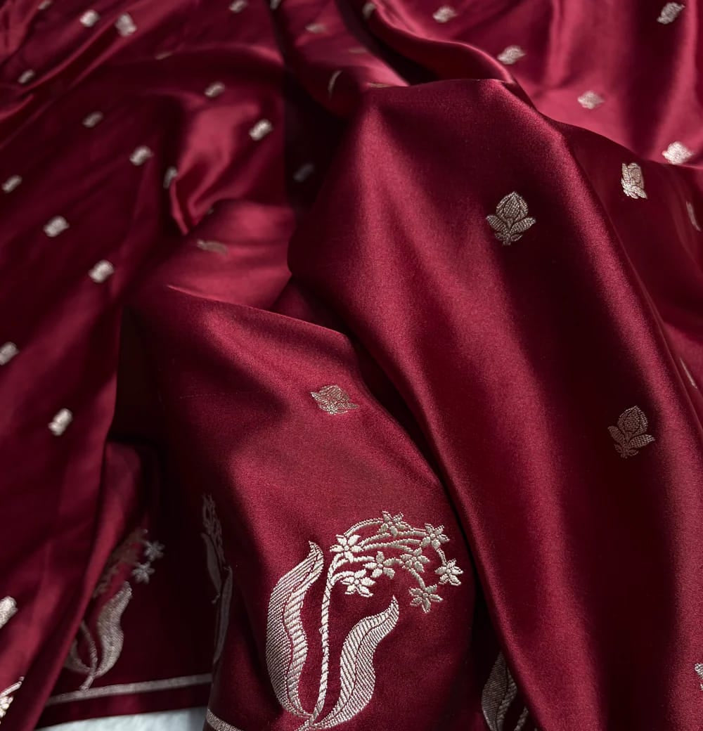 Close-up of a maroon fabric with floral embroidery on a white background