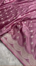 Pink fabric with intricate silver embroidery on a white background