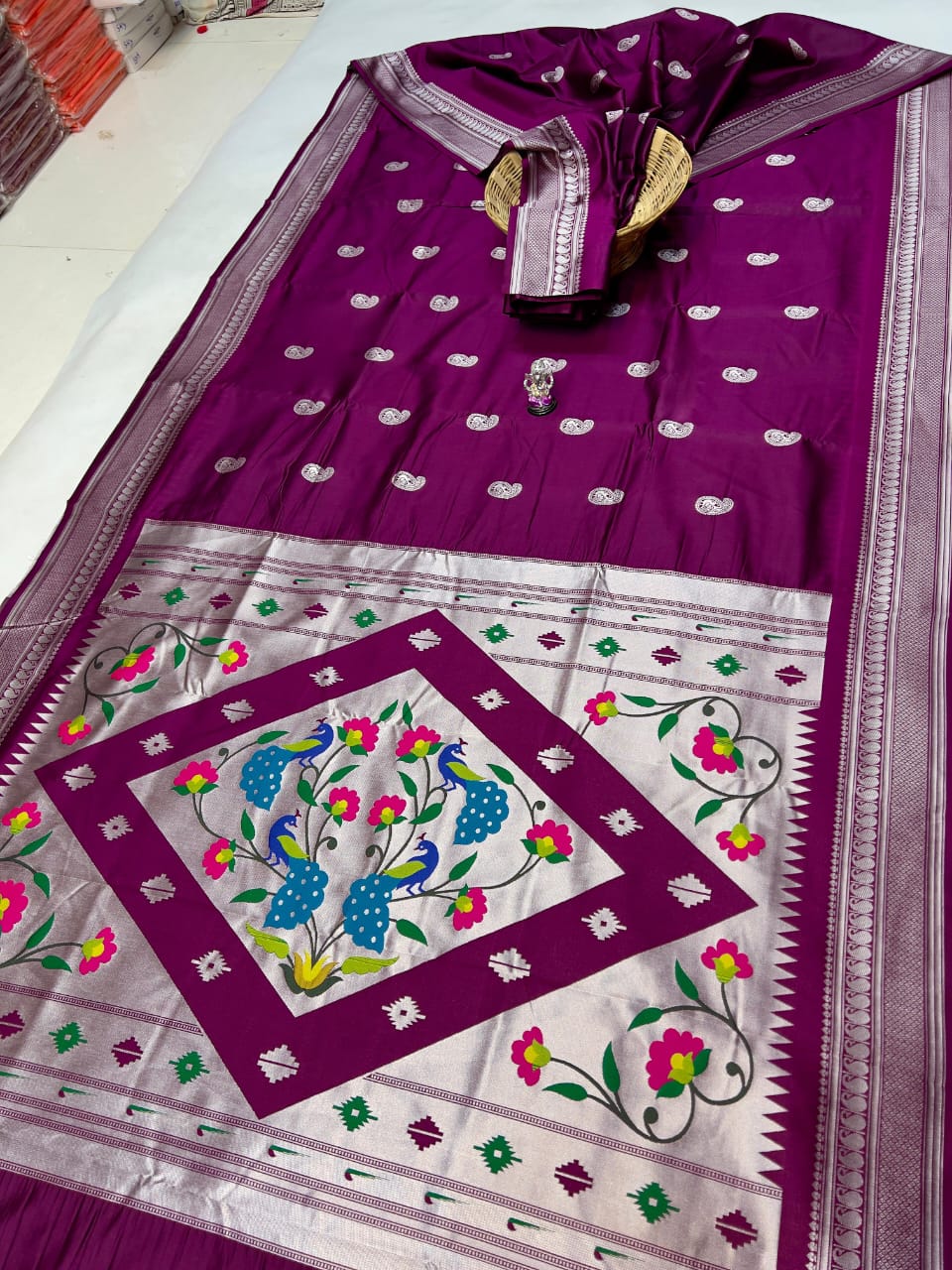 Purple and white saree with floral patterns on a plain background