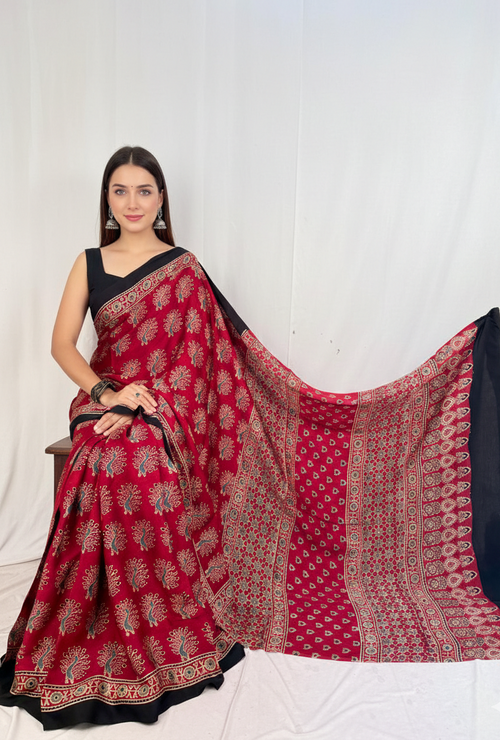 Woman wearing a red and black saree with a white background