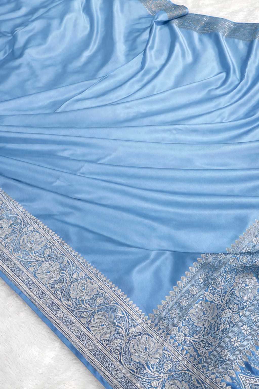 Light blue fabric with intricate patterns on a white background