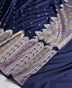 Navy blue fabric with intricate white and multicolor embroidery