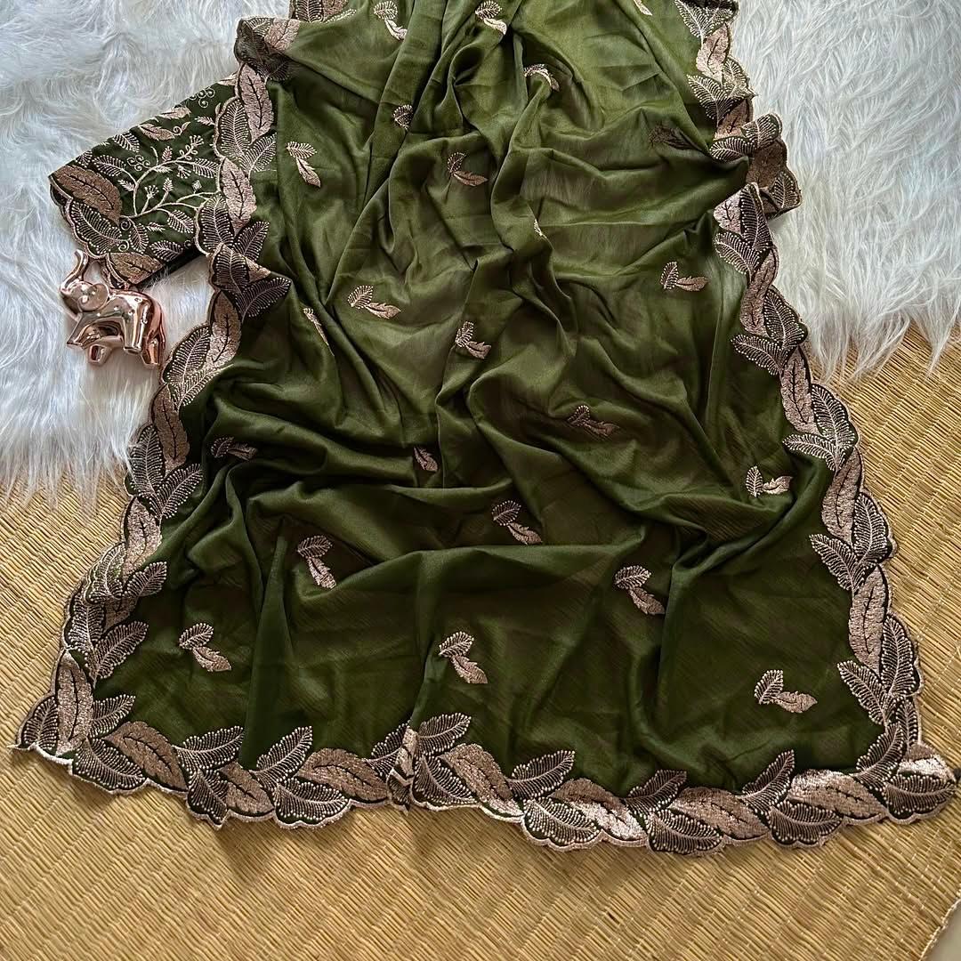 Green fabric with brown floral embroidery on a textured surface