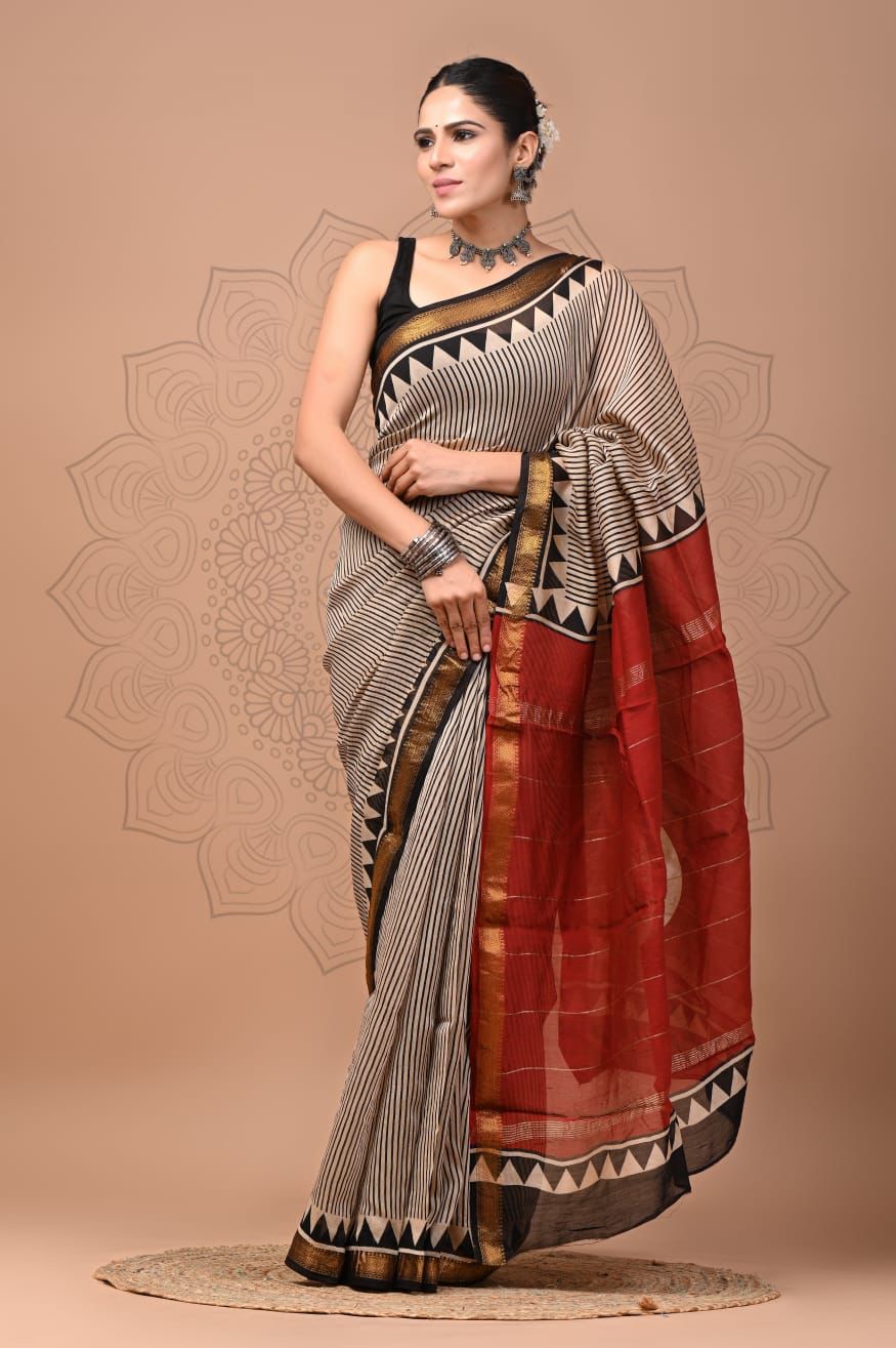 Woman wearing a traditional saree with a geometric pattern on a beige background