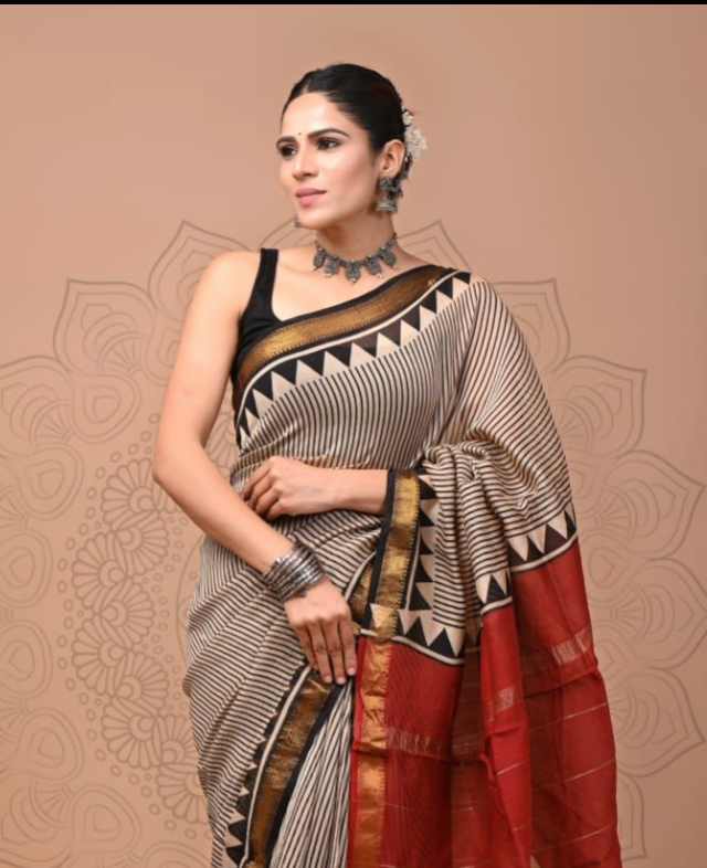 Woman wearing a traditional saree with a geometric pattern on a beige background