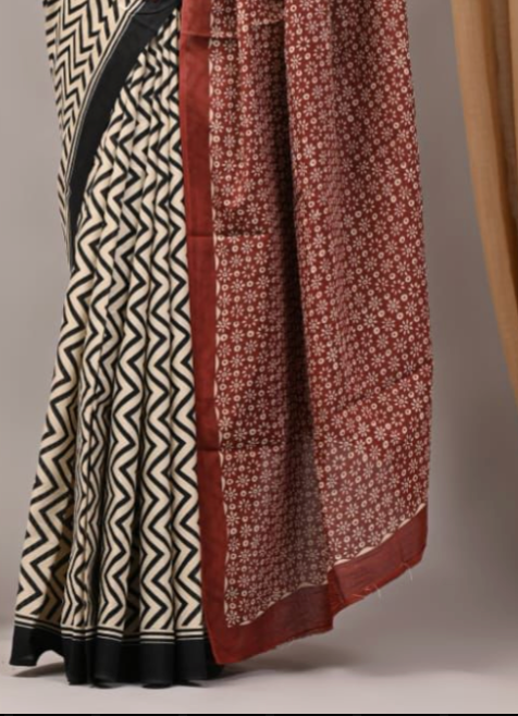 Two patterned scarves, one with black and white zigzag design and the other with red and white floral design, draped over a neutral background.