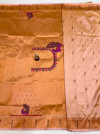 Brown saree with intricate embroidery and a decorative brooch on a white background