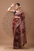 Woman wearing a maroon saree with a pattern on a beige background