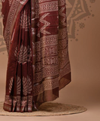 Brown saree with white patterns on a neutral background