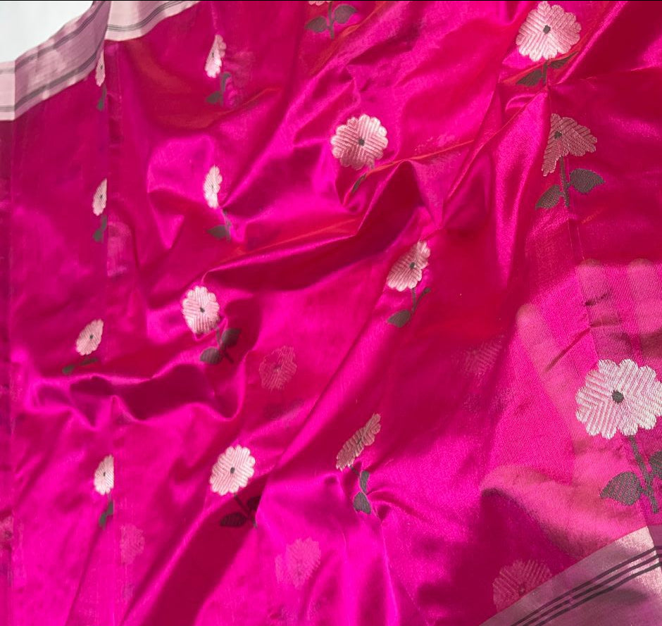 Close-up of a pink saree with floral patterns and a white background