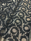 Dark fabric with intricate beige floral and vine patterns