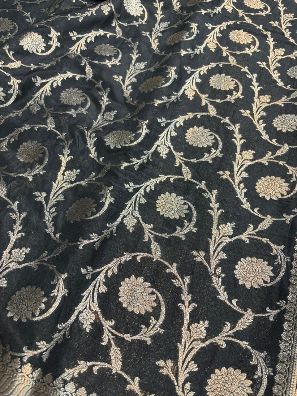 Dark fabric with intricate beige floral and vine patterns