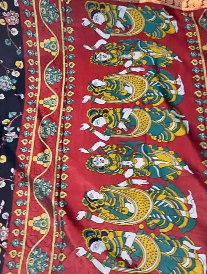 Colorful fabric with intricate designs and figures on a red background