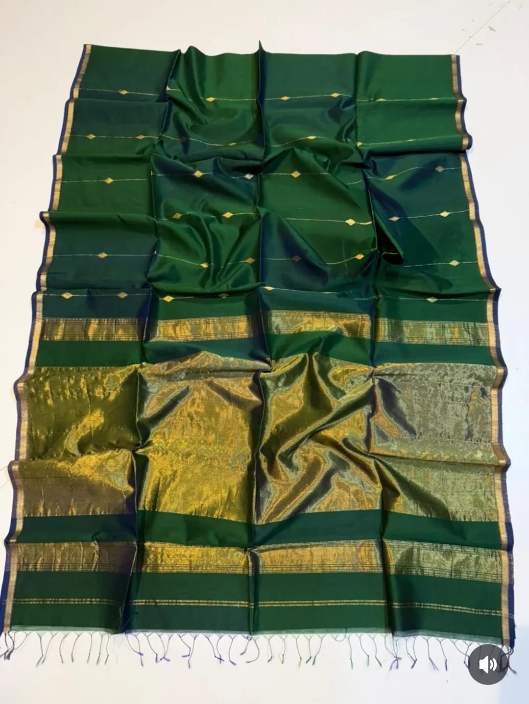 Green and gold saree with a pattern on a white background