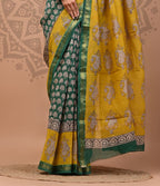 Woman wearing a green and yellow saree with a decorative background