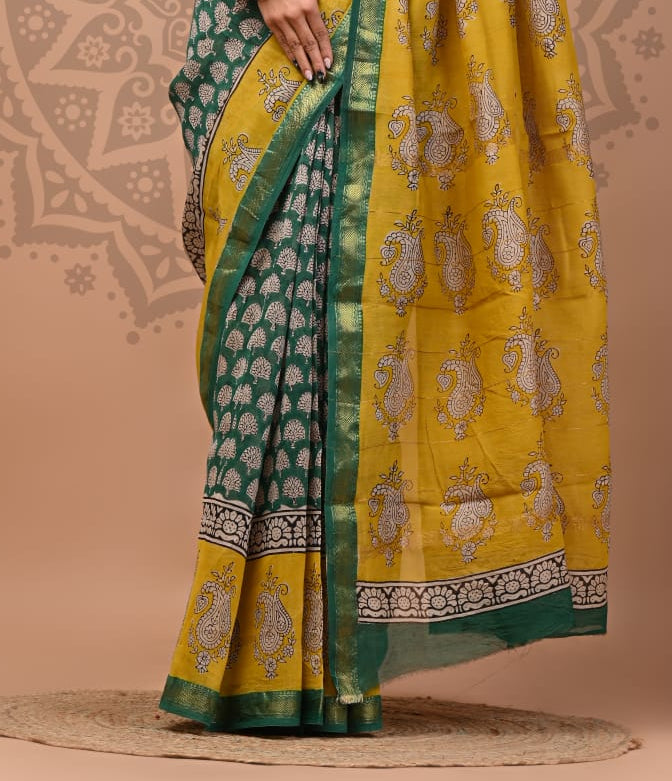 Woman wearing a green and yellow saree with a decorative background