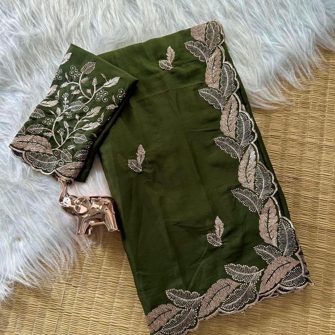 Green saree with floral embroidery on a textured surface
