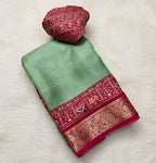 Green and red saree with floral decorations on a white background