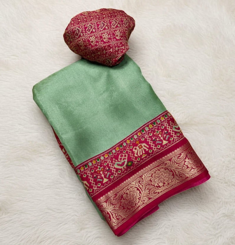 Green and red saree with floral decorations on a white background