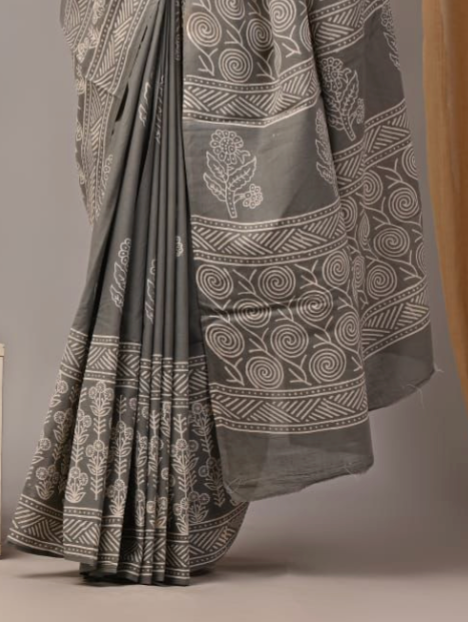 Gray saree with white floral and geometric patterns on a plain background