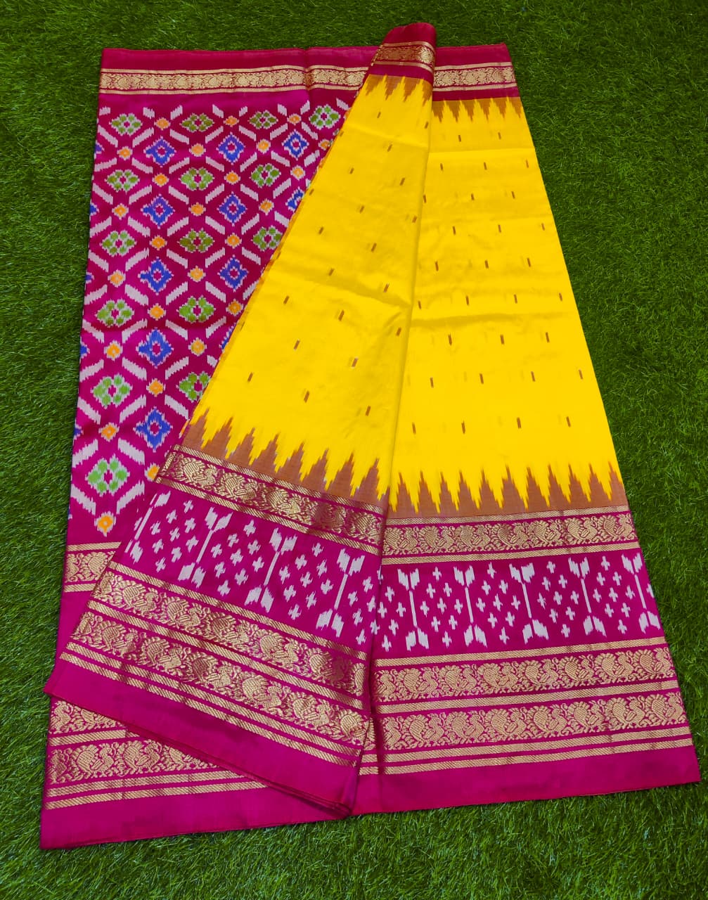 Yellow and pink saree with intricate patterns on a green background