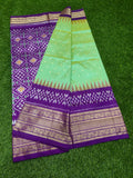 Purple and green saree with intricate patterns on a green background