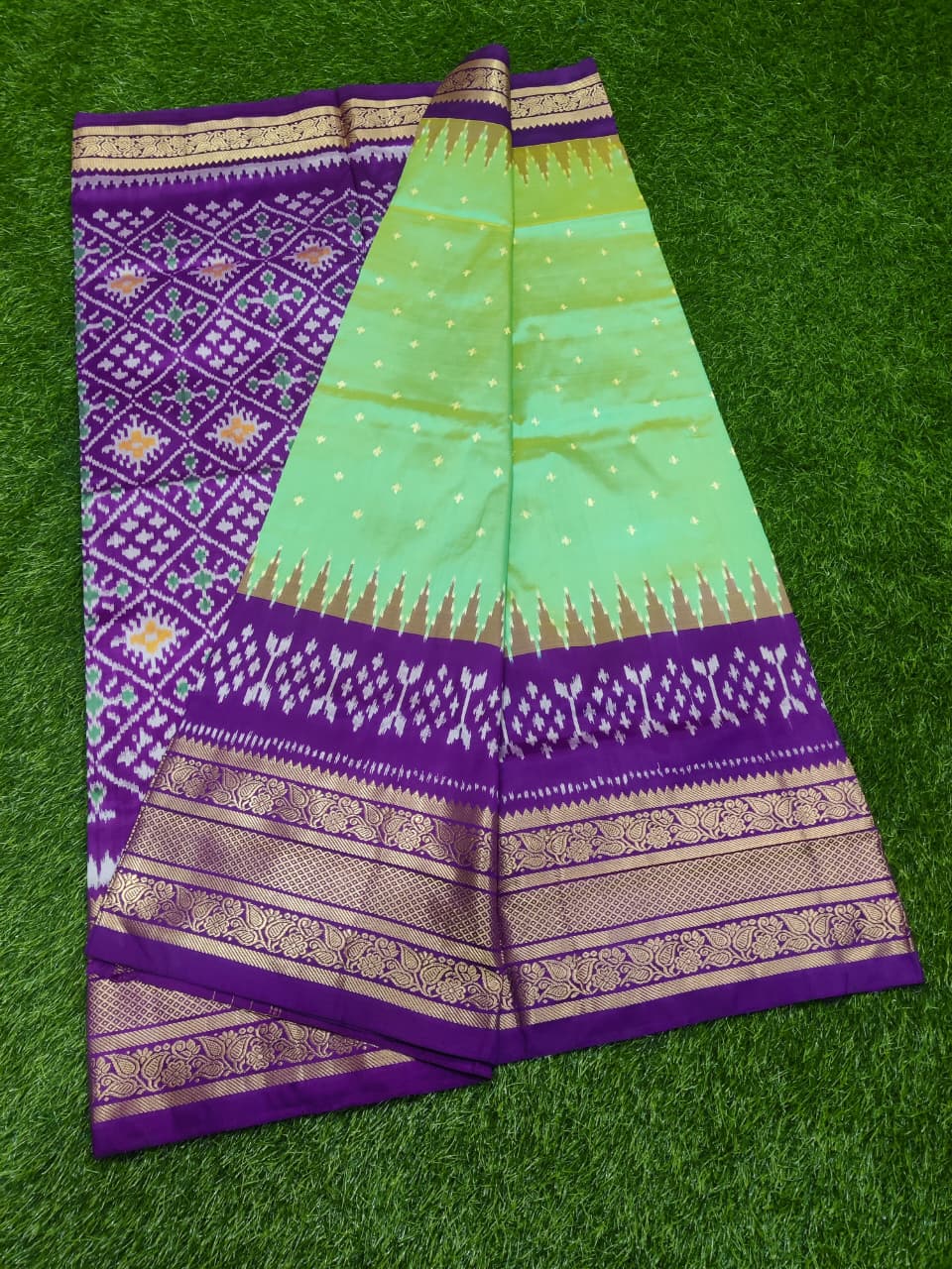 Purple and green saree with intricate patterns on a green background