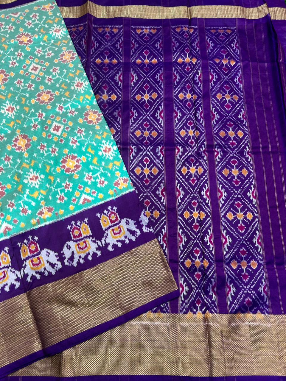 Saree with colorful patterns on a green, purple, and gold background