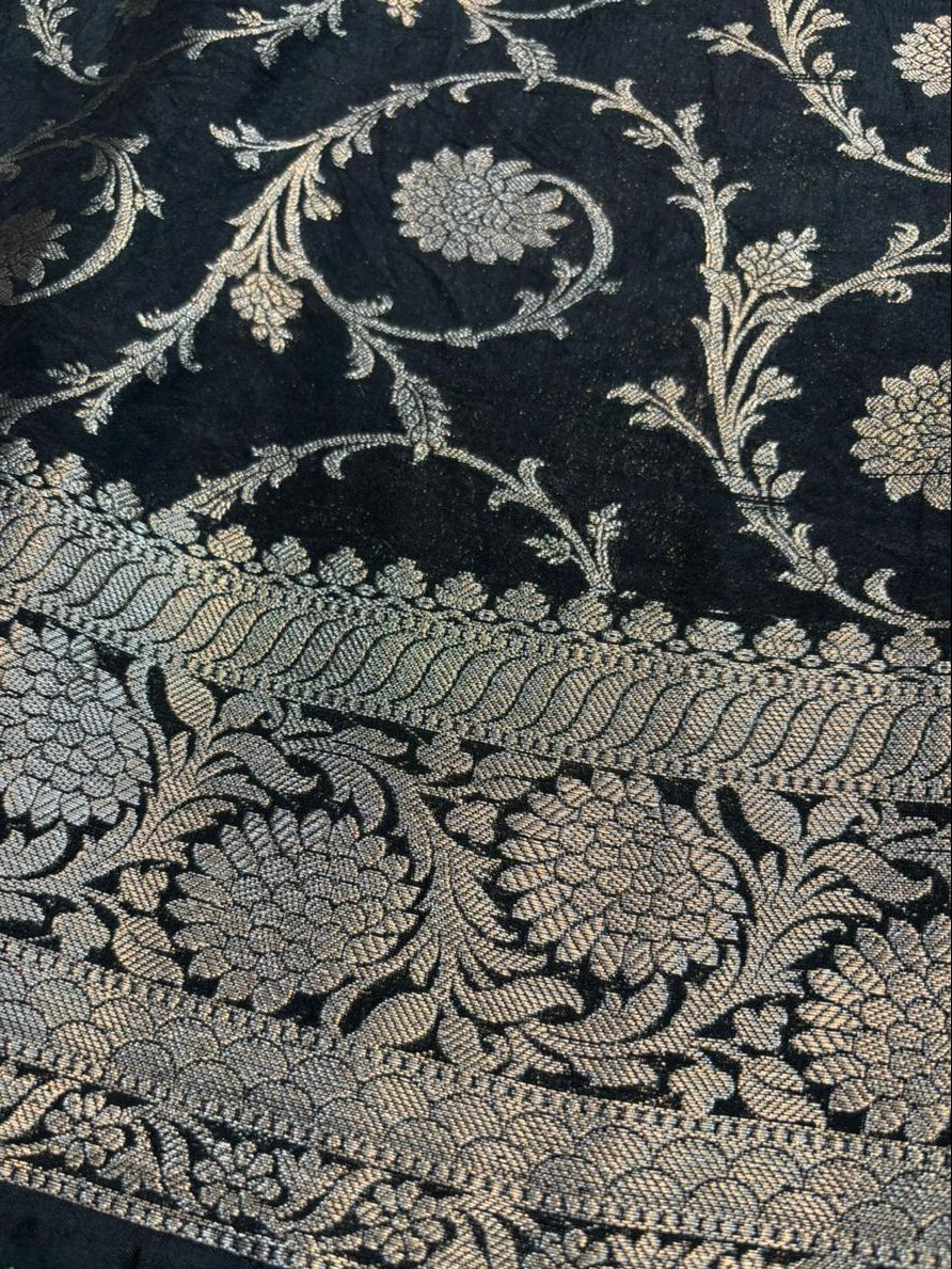 Close-up of black fabric with intricate gold floral embroidery