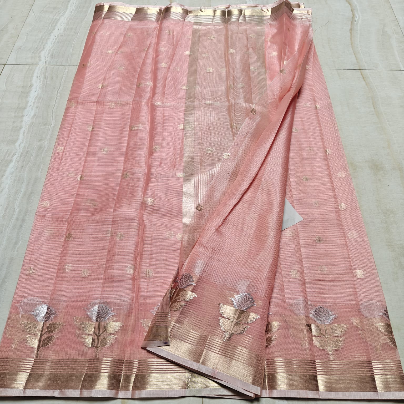 Pink saree with gold patterns on a light gray background