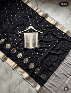 Black saree with gold border and silver blouse on a hanger against a marble background