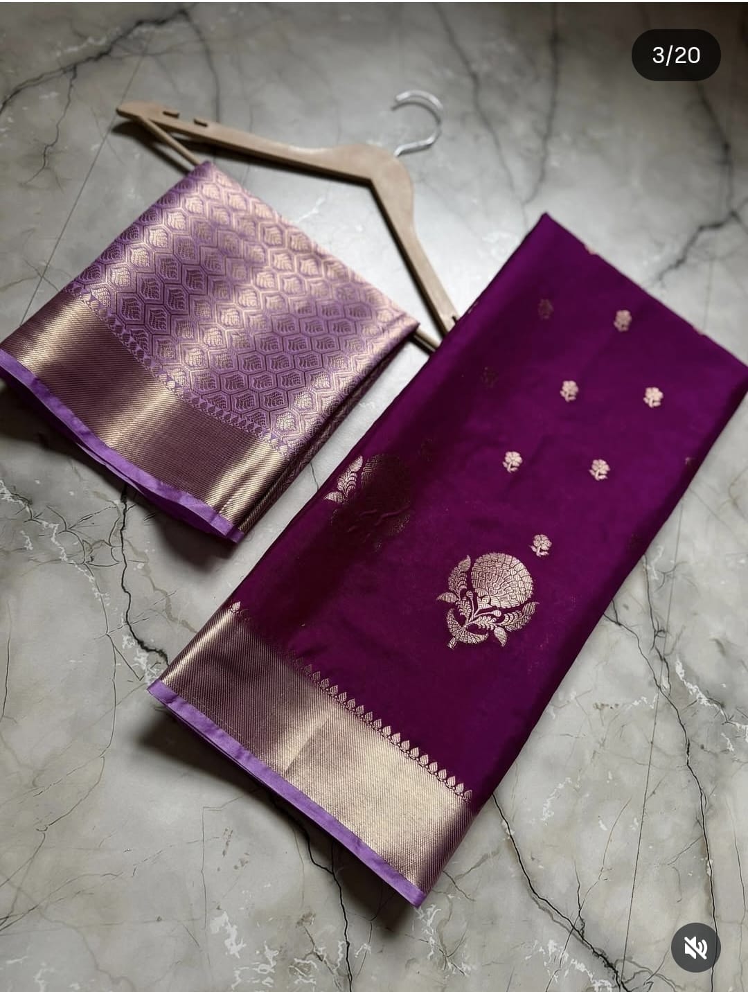 Two purple sarees with gold patterns on a gray marble surface