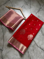 Red and pink saree with floral patterns on a marble surface