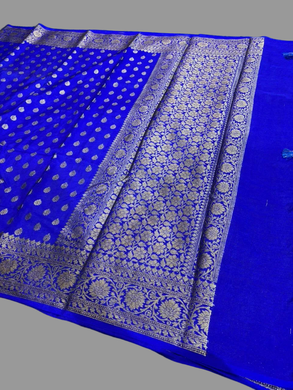 Blue saree with silver border on a green grass background