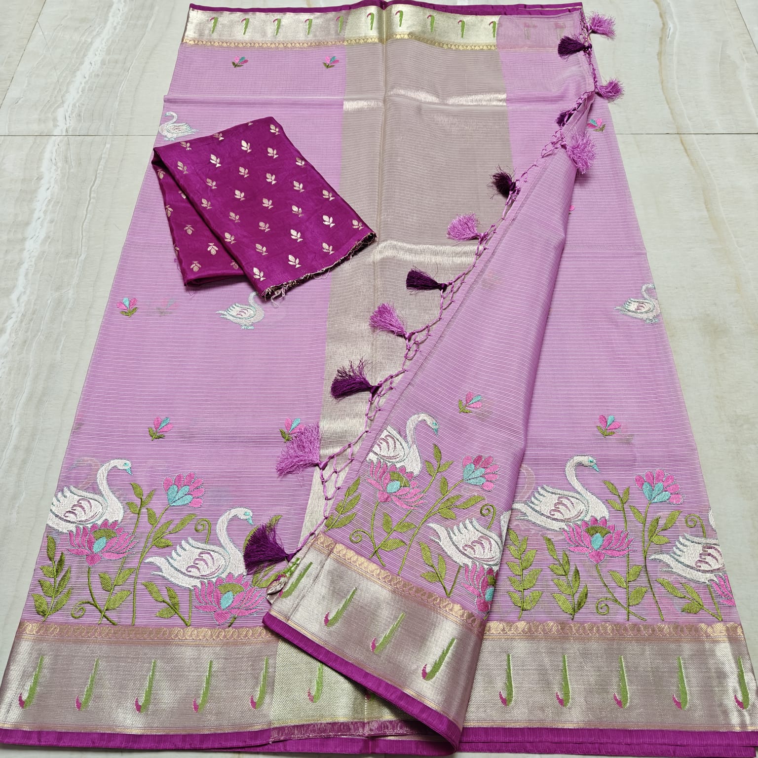 Purple saree with floral and swan patterns on a white background