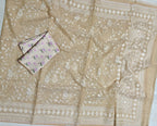 Beige fabric with white floral embroidery and a folded pink fabric with purple flowers on a white background