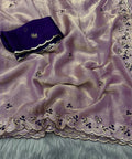 Purple fabric with intricate embroidery on a textured surface