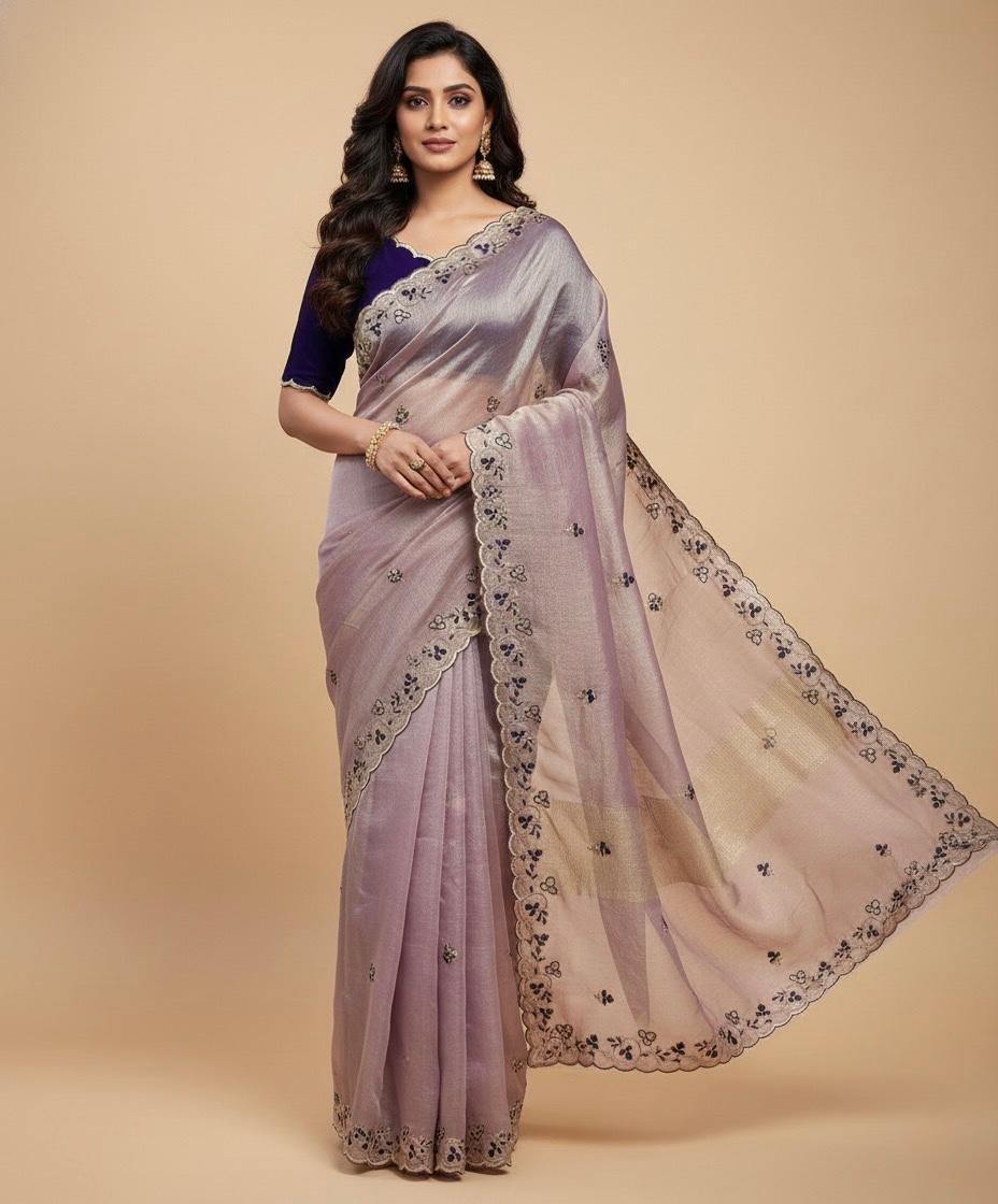 Woman wearing a light purple saree with a beige background