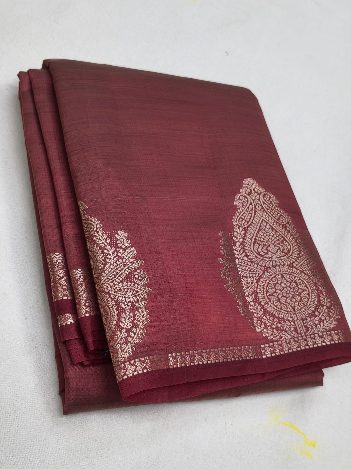 Maroon saree with white embroidery on a white background
