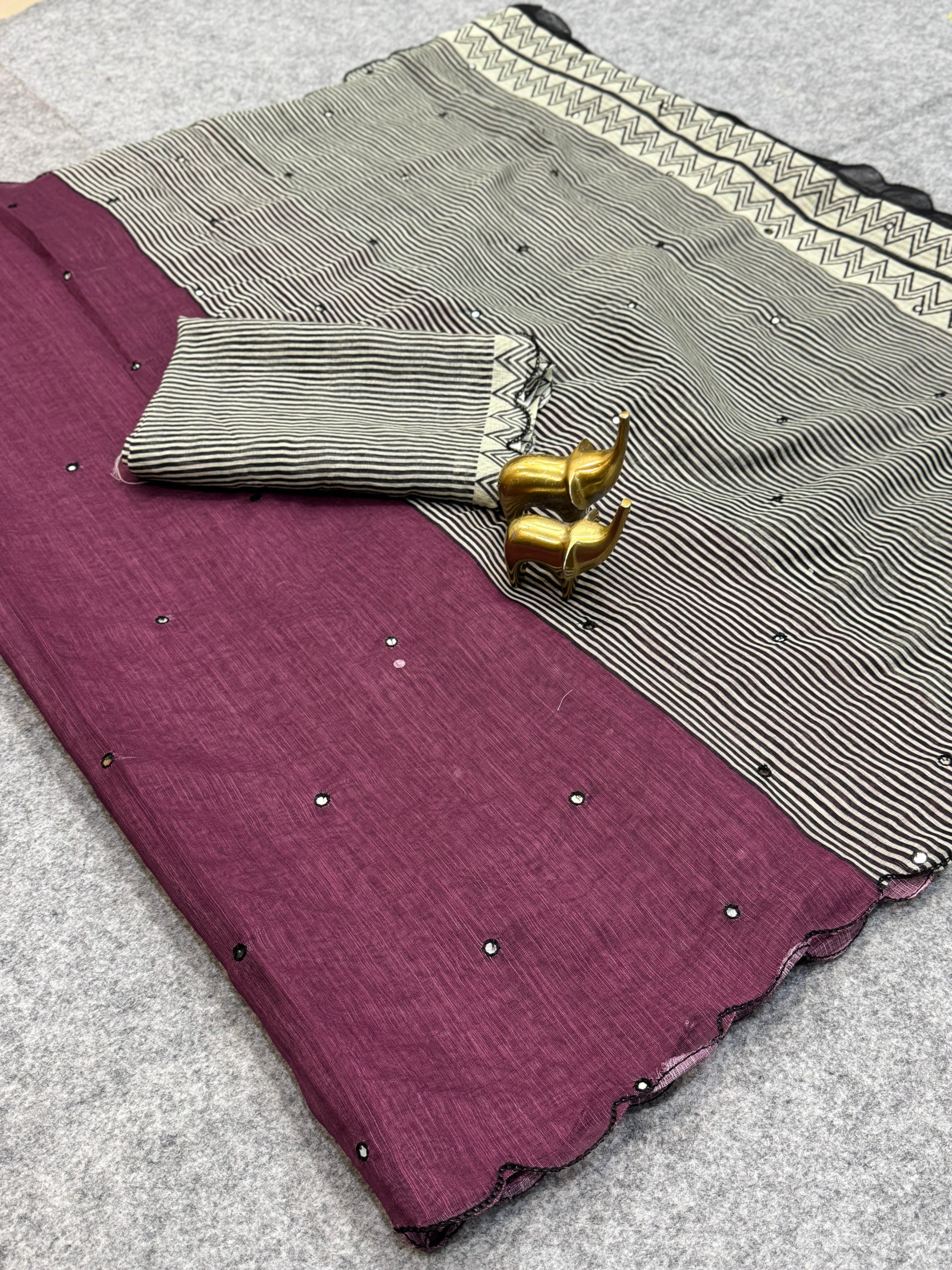 Purple fabric with a patterned border on a gray surface