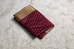 Maroon saree with gold patterns on a white surface, branded 'ZIVRA'.